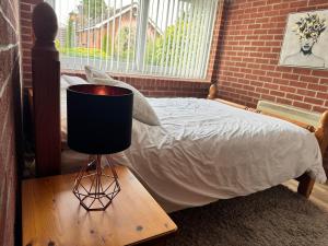 a bedroom with a bed and a lamp on a table at The pool house in Bedford +12 photos