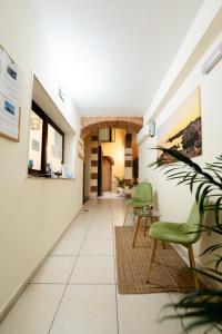 a hallway with green chairs and a table at Porta delle Botteghelle in Trapani