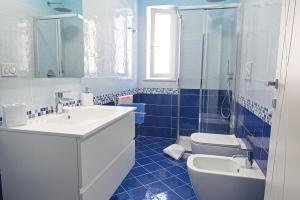 a blue and white bathroom with a sink and a toilet at Appartamento Celestina Mare in Portoferraio
