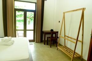 a bedroom with a bed and a mirror and a desk at Abey Villa Madiha Beach Surf Stay in Matara