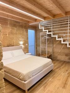 a bed in a room with a brick wall at Petra dimora leccese in Lecce