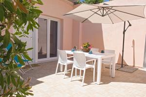 a table and chairs with an umbrella on a patio at Appartamento Celestina Mare in Portoferraio +7 photos