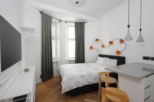 a white bedroom with a bed and a table at Stylish studio in the centre in Helsinki