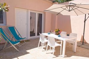 a patio with a table and chairs and an umbrella at Appartamento Celestina Mare in Portoferraio