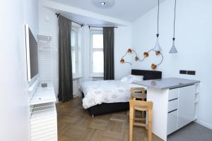 a white bedroom with a bed and a desk at Stylish studio in the centre in Helsinki