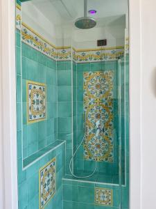a blue tiled bathroom with a shower with a mosaic at Hotel Ristorante Colleverde in Santa Maria di Castellabate +89 photos