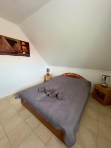 a bedroom with a bed with a purple blanket at Marilyn Apartman Gyenesdiás in Gyenesdiás
