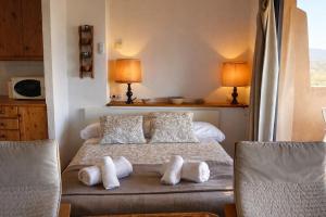 a bedroom with a bed and two chairs at Loft con chimenea y terraza con vistas - Cal Caterino in Montsonis