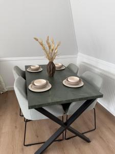 a green table with chairs and a vase with flowers at IL Mulino House D, keukenhof in Hillegom