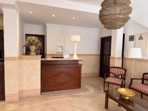 a lobby with a reception desk and chairs at Hotel Victoria Matalascañas in Matalascañas