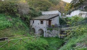 a small stone building on a hill with a tunnel at Colle Muzia B&B e Affittacamere in Muccia