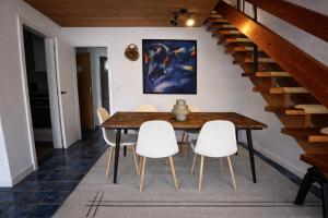 a dining room with a wooden table and white chairs at Ferienwohnung Steinbock mit Bergblick in Bayrischzell