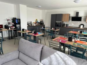 a living room with tables and chairs and a couch at Colle Muzia B&B e Affittacamere in Muccia