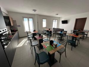 a room with tables and chairs in a kitchen at Colle Muzia B&B e Affittacamere in Muccia