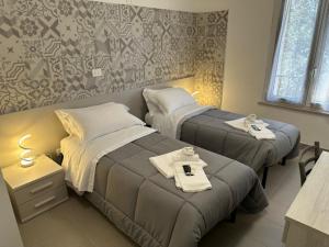 a hotel room with two beds with towels on them at Colle Muzia B&B e Affittacamere in Muccia