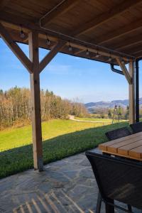 a patio with a table and chairs and a view of a field at Skalne Wzgórze in Ochotnica Dolna