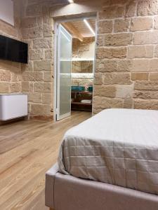 a bedroom with a bed and a stone wall at Petra dimora leccese in Lecce