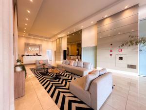a living room with two couches and a rug at Ribeirão Premium Apogeo in Ribeirão Preto