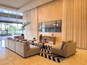 a living room with two couches and a table at Ribeirão Premium Apogeo in Ribeirão Preto