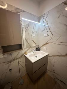 ein Badezimmer mit Waschbecken und Spiegel in der Unterkunft Casa Delmo Comfort, eleganza e posizione strategica nel cuore della Valtellina in Sondrio + 14 Fotos