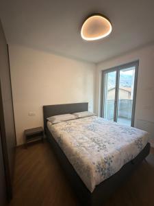 ein Schlafzimmer mit einem Bett und einem großen Fenster in der Unterkunft Casa Delmo Comfort, eleganza e posizione strategica nel cuore della Valtellina in Sondrio