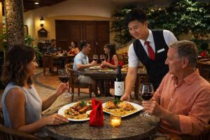 a group of people sitting at a table with food and wine at Pacific Club Resort in Karon Beach