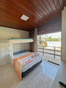 a bedroom with a bunk bed and a balcony at Hotel 5km da Guarda do Embaú in Palhoça +5 photos