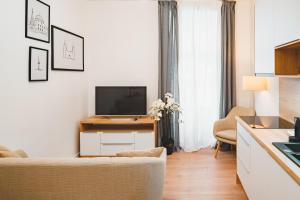 a living room with a television and a couch at Tímár 18 Apartman in Pécs