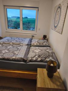 a bed in a room with a window at Kleine Auszeit Eifel mit Dachterrasse in Nettersheim