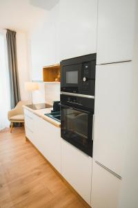 a kitchen with a microwave and a refrigerator at Tímár 18 Apartman in Pécs