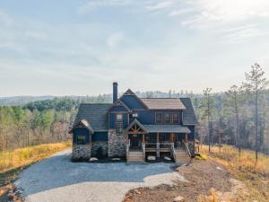 a blue house on a hill with a driveway at Blue Salamander Lodge in Talking Rock