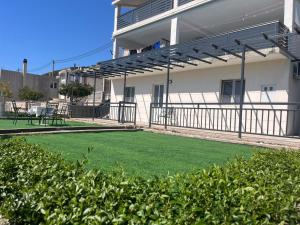 a yard with a lawn in front of a building at Apartman M&D in Neum