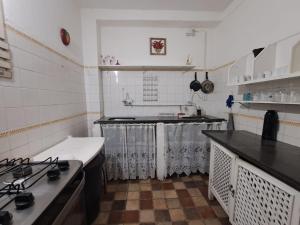 a kitchen with a stove and a counter top at Suites & Hostel Manjericão in Paraty