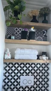 a bathroom shelf with plants and a black and white tiles at Private big Apartment in Eversdal