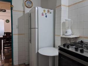 a kitchen with a refrigerator and a table next to a stove at Suites & Hostel Manjericão in Paraty +24 photos