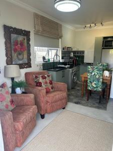 a living room with two couches and a kitchen at Private big Apartment in Eversdal