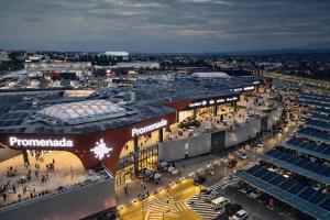 an aerial view of a shopping center with a lot of cars at Novus Luxury Apartment Free Parking in Craiova