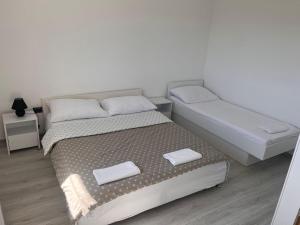 a bedroom with two beds with towels on them at Apartman M&D in Neum