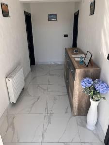 a hallway with a vase of flowers on a marble floor at Apartman M&D in Neum +5 photos
