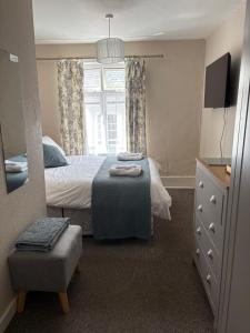 a bedroom with a bed and a window and a chair at Hideway Dartmouth in Dartmouth