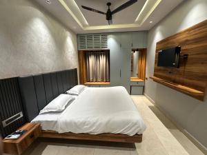 a bedroom with a bed and a flat screen tv at Vrs Homestay in Mayiladuthurai