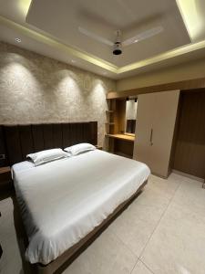 a bedroom with a large bed with white sheets at Vrs Homestay in Mayiladuthurai