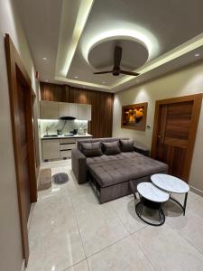 a living room with a couch and two tables and a kitchen at Vrs Homestay in Mayiladuthurai