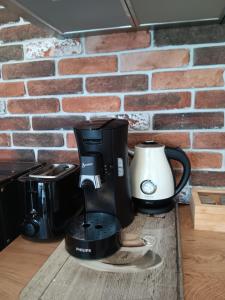 a coffee maker sitting on a wooden table in front of a brick wall at Dido House Panoramic -Eurovision Fans Hub 2027 in Veliko Tŭrnovo +18 photos