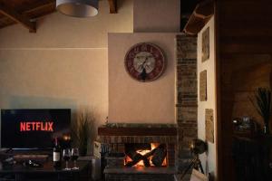 a clock on the wall above a fireplace at Pierian Chalets by TETOS - Grand in Velventós