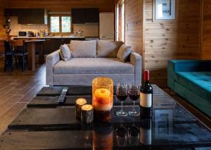 a living room with a couch and two glasses of wine at Pierian Chalets by TETOS - Grand in Velventós