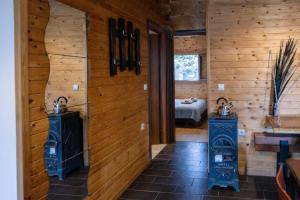 a room with wooden walls and a bedroom with a bed at Pierian Chalets by TETOS - Grand in Velventós