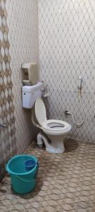 a bathroom with a toilet and a bucket at Hotel Shree palace in Jabalpur