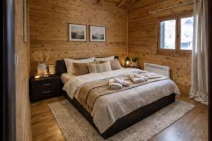 a bedroom with a bed with two towels on it at Pierian Chalets by TETOS - Grand in Velventós +19 photos