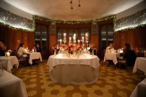 ein Esszimmer mit einem Tisch voller Blumen und Kerzen. in der Unterkunft Al Borducan Boutique Hotel in Varese